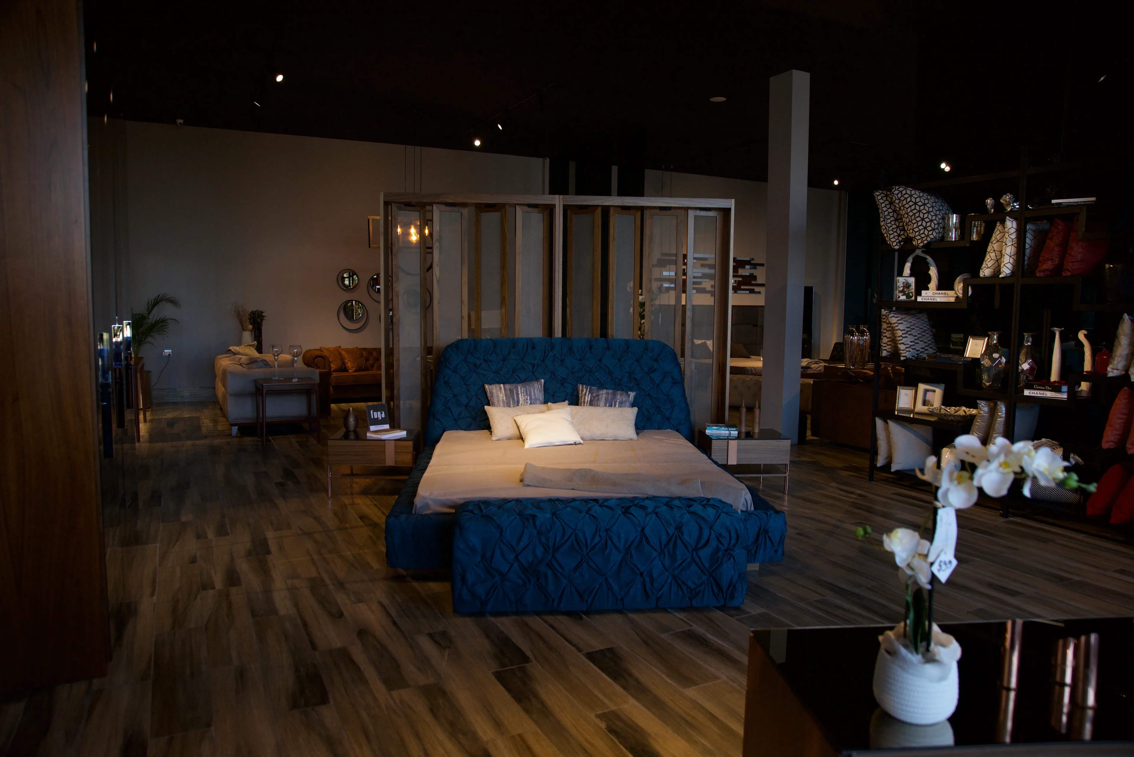 A bedroom with hard wood floors and blue furniture.