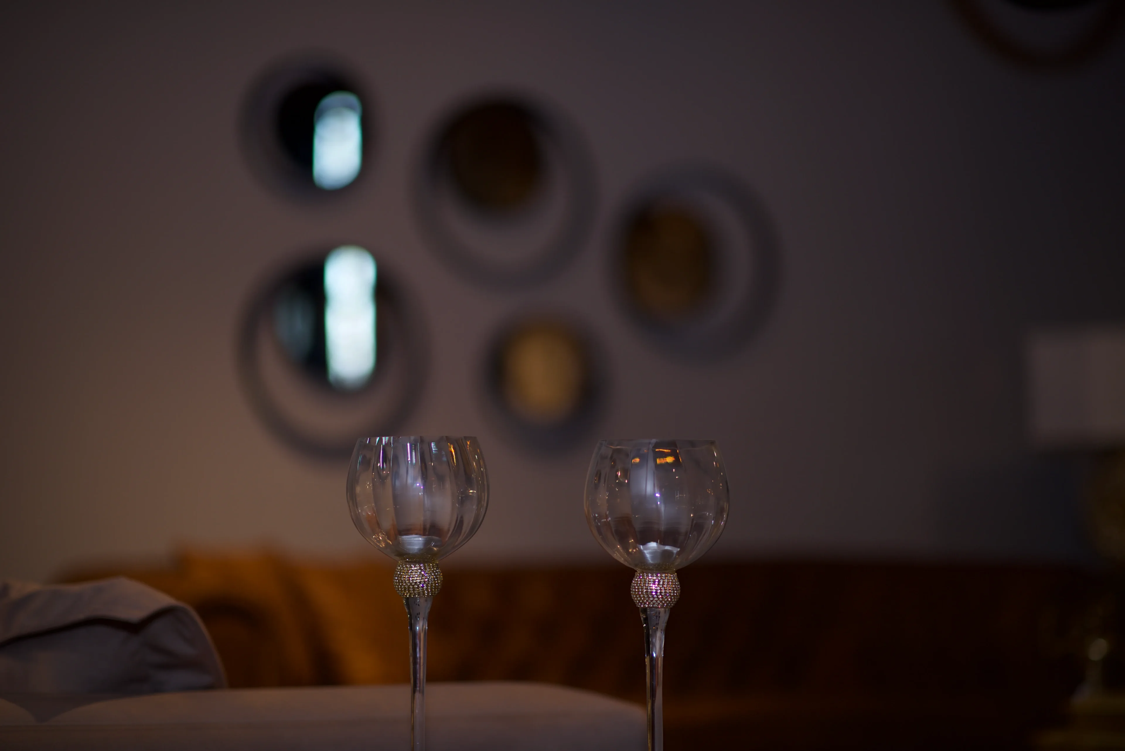 Two wine glasses are sitting on a table.