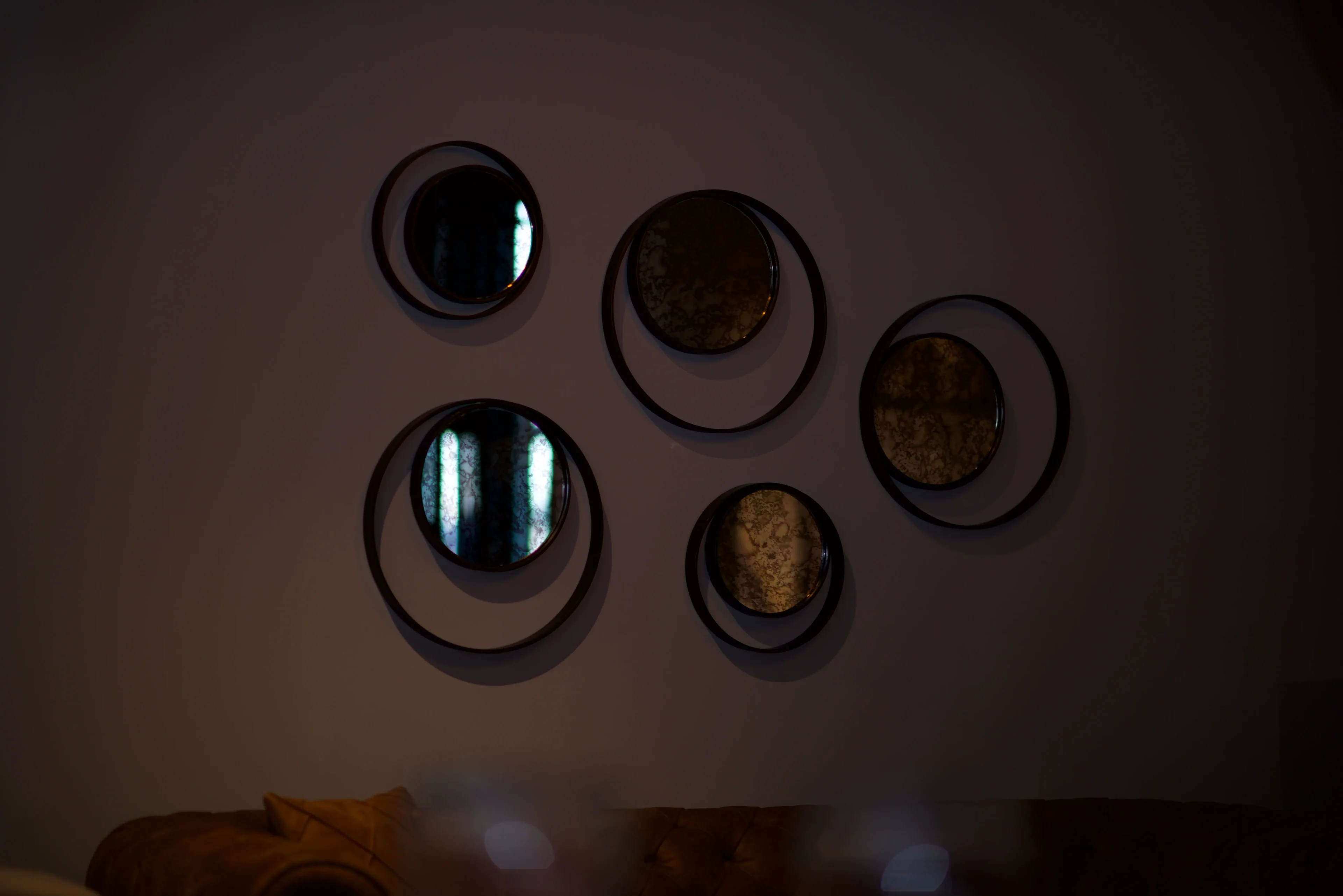 A wall with several circular mirrors on it.