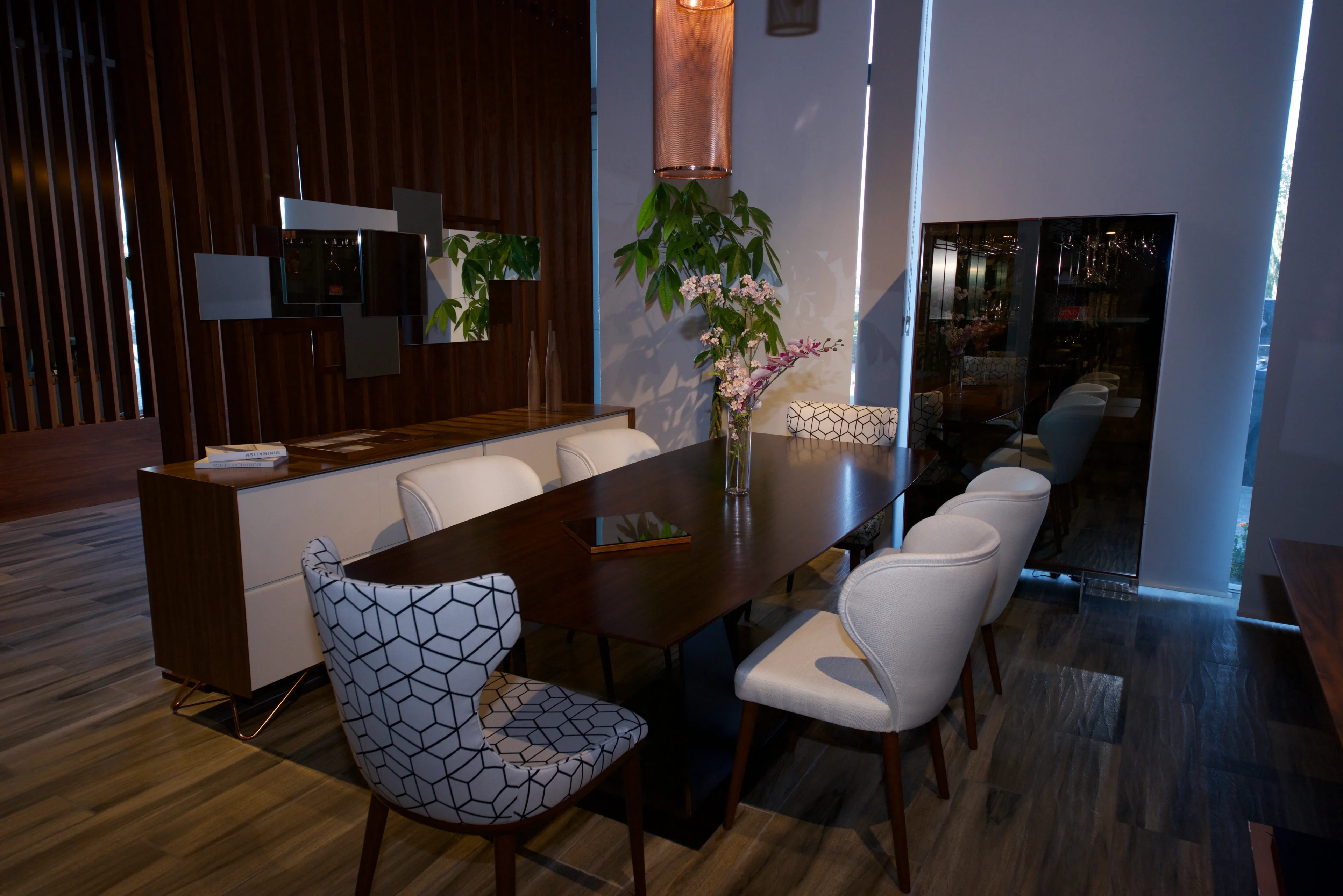 A dining room table with chairs and a plant.