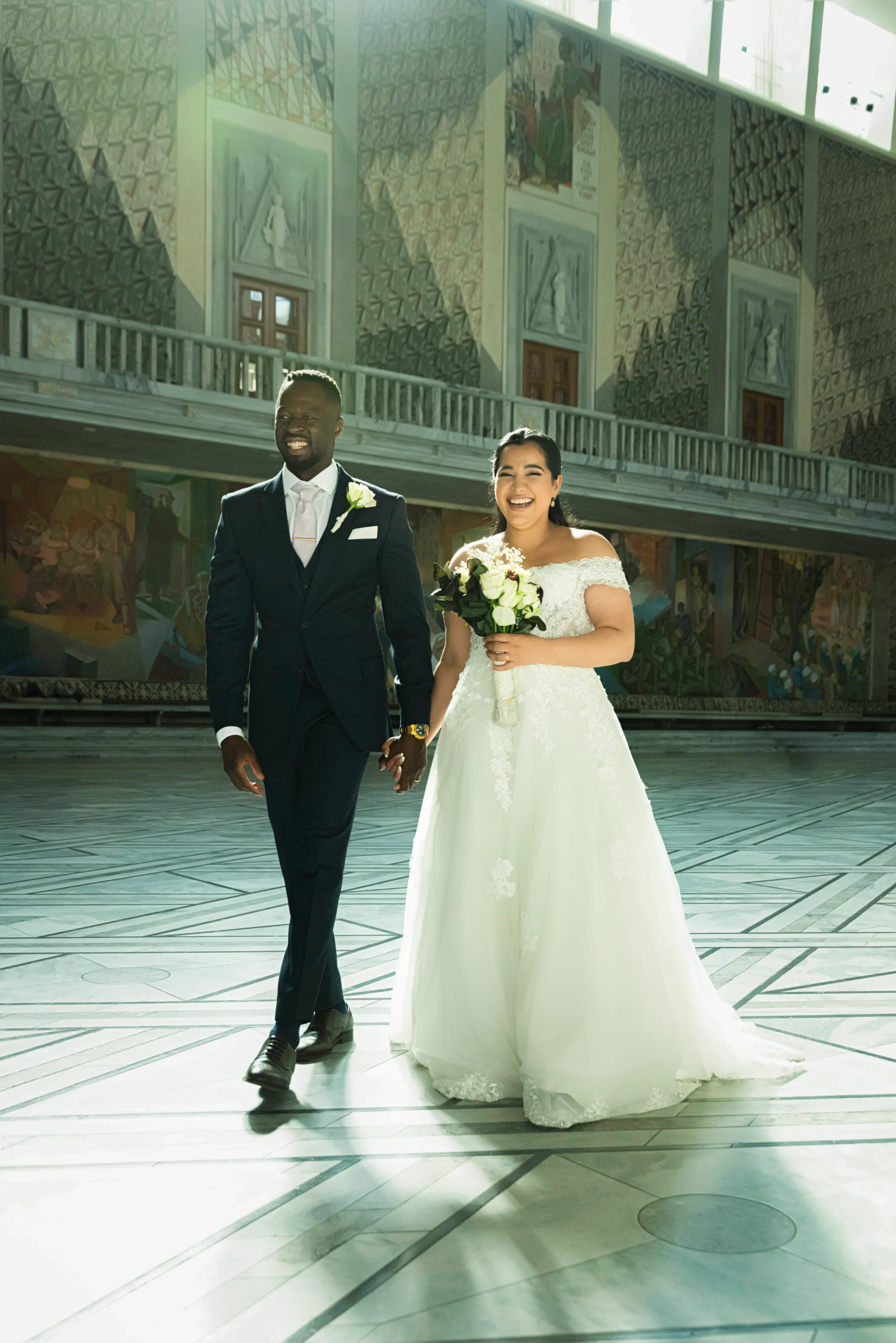 A man and woman walking in front of an old building.