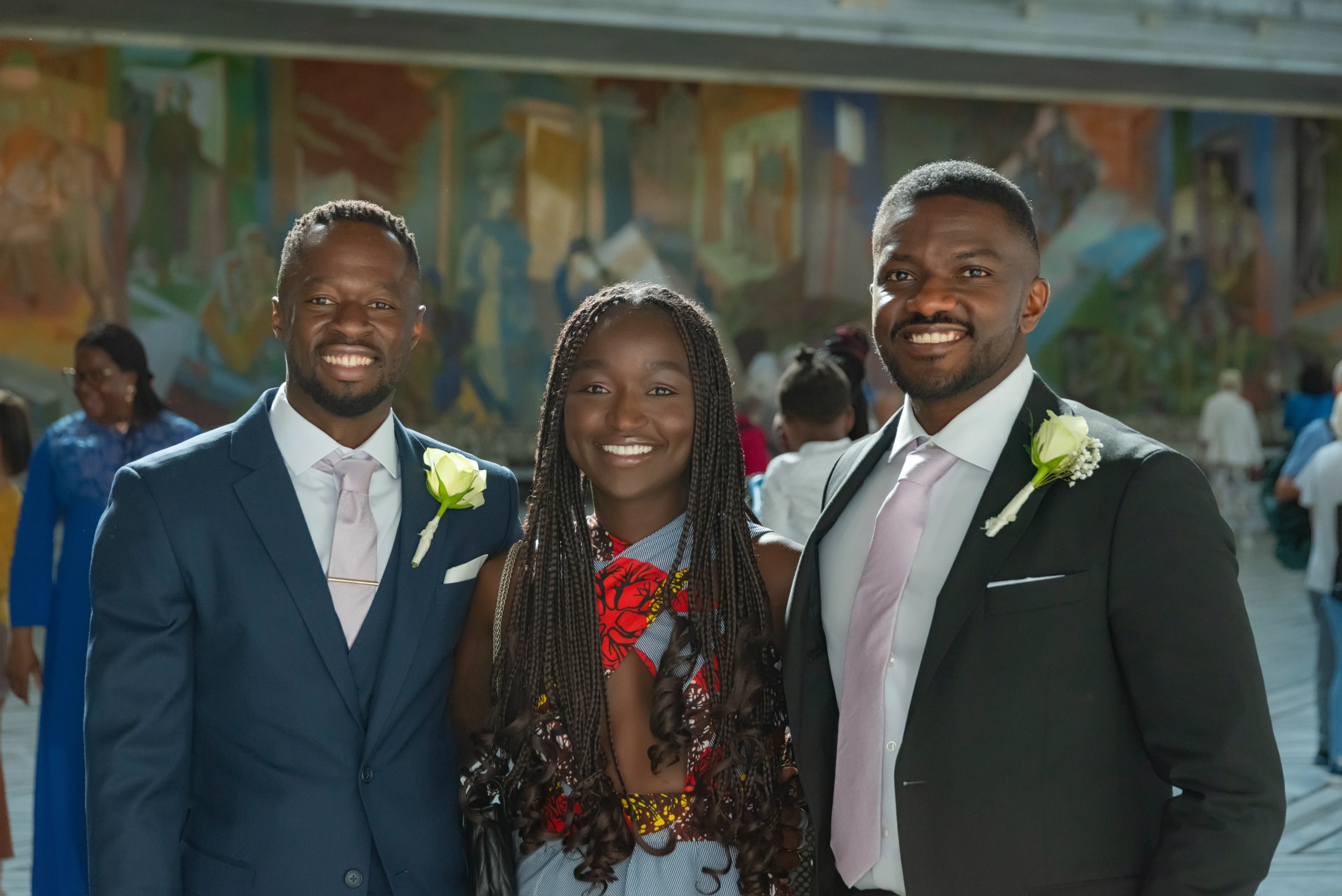 Three people in suits and ties posing for a picture.